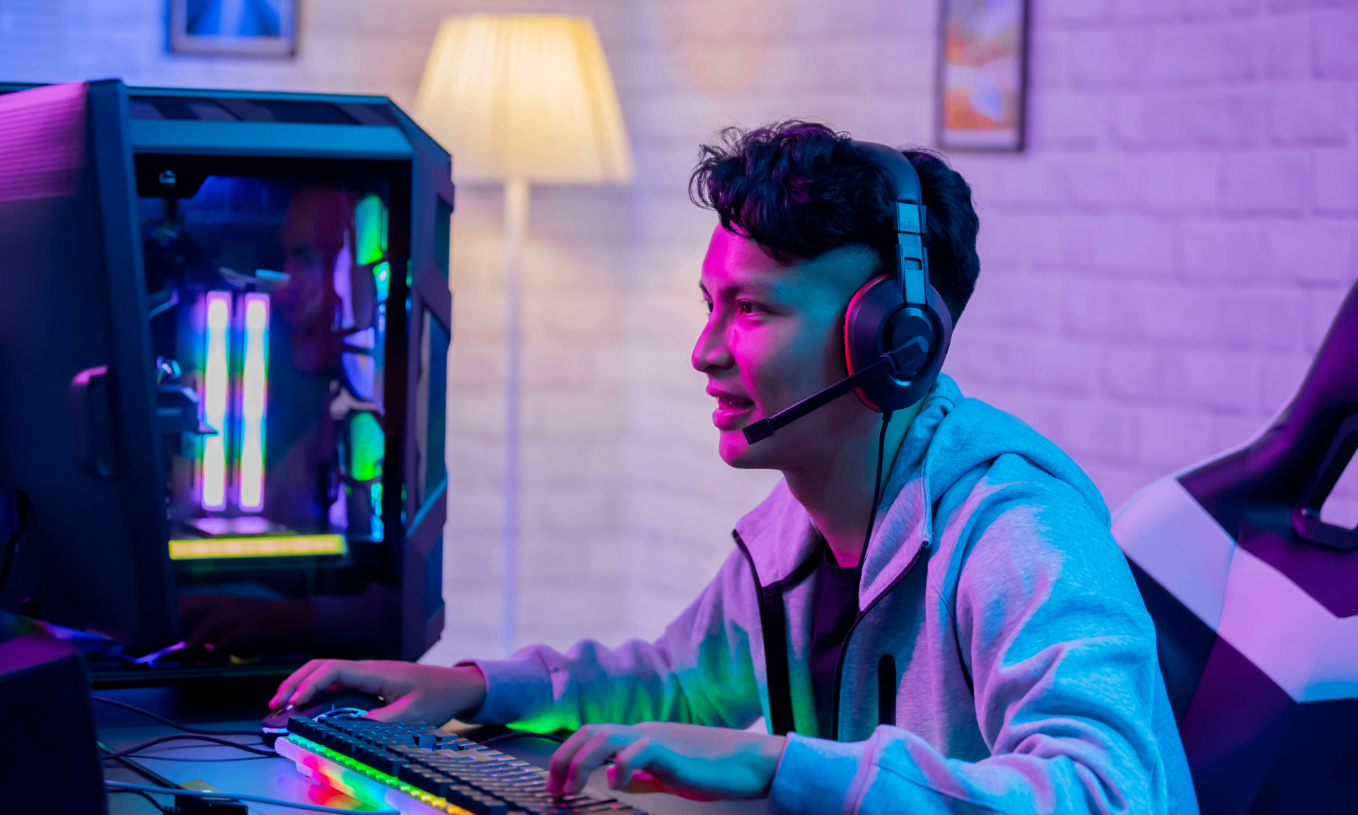 Ung person med headset spelar dator i färgglatt neonljus